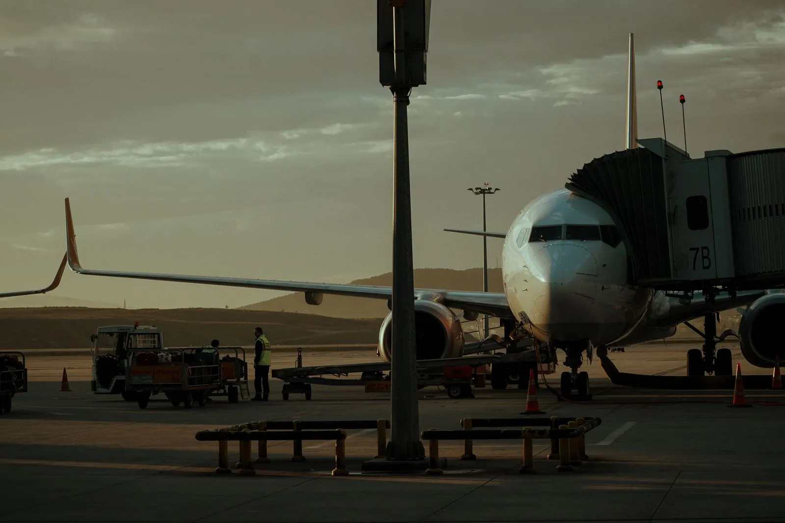 A passenger aircraft parked at the gate at Tivat Airport at sunset